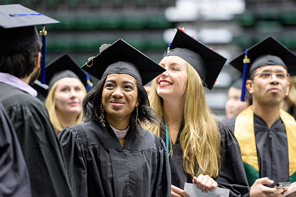 Students smile and cheer during commencement