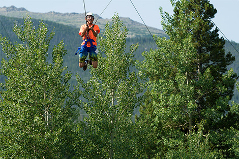 A high school student on the ropes course in mountains